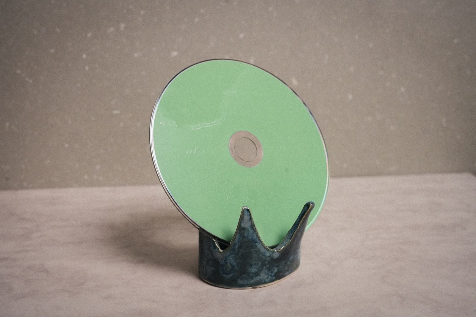 綠色 CD 立於王冠形陶座上